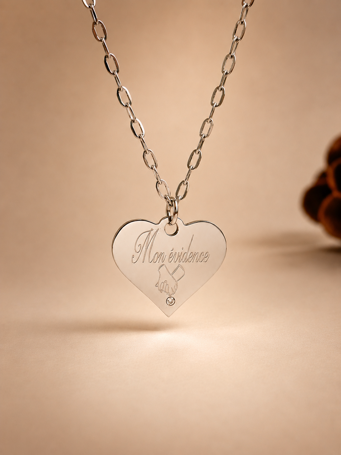     Détail du collier femme personnalisé en acier inoxydable argent avec pendentif cœur serti d’un zircon.